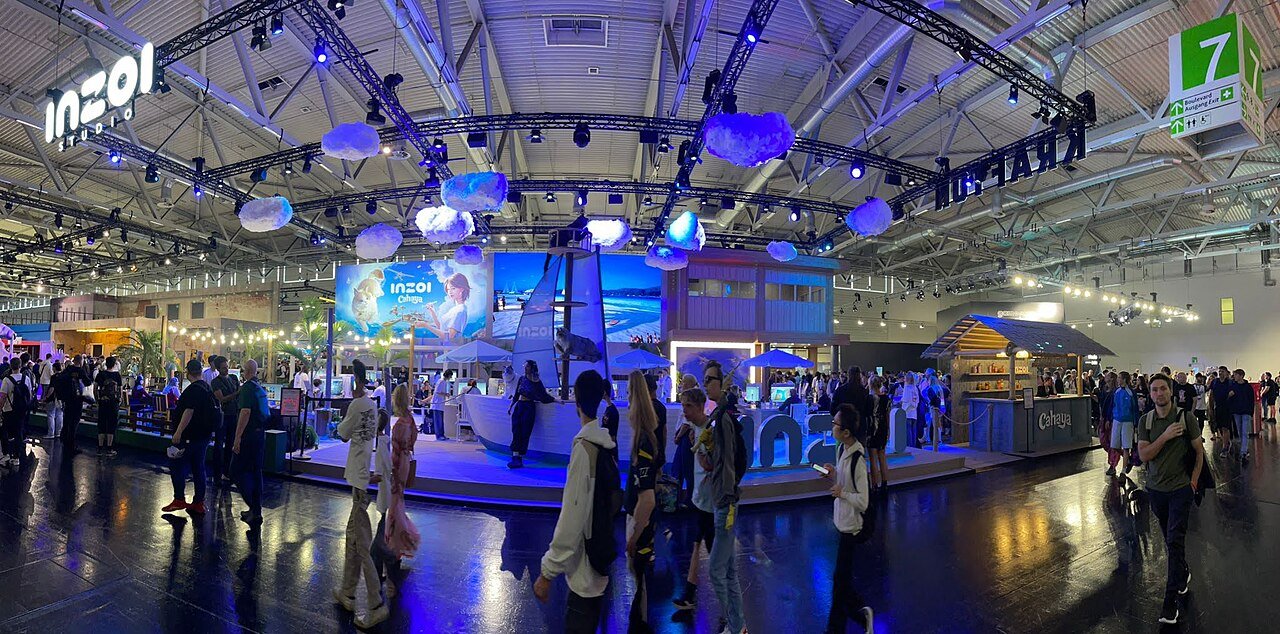 Pavilhão da gamescom com estande iluminado e público circulando entre as atrações da feira