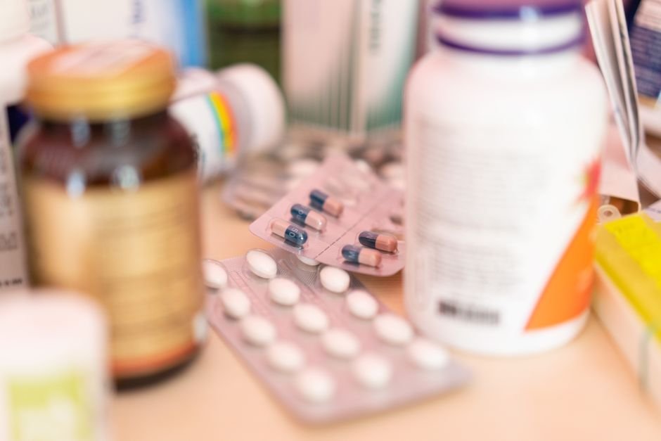 Cartelas, frascos e caixas de medicamentos sobre uma superfície