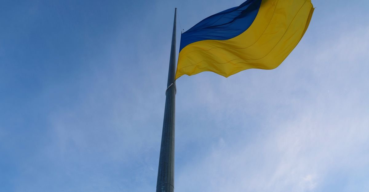 Bandeira da Ucrânia hasteada em mastro contra o céu azul