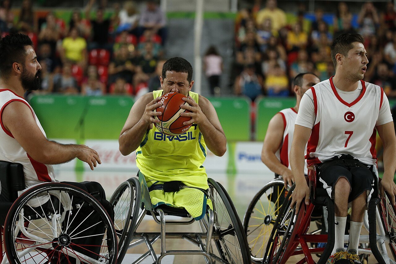 Atleta da seleção brasileira de basquete em cadeira de rodas com a bola em partida internacional