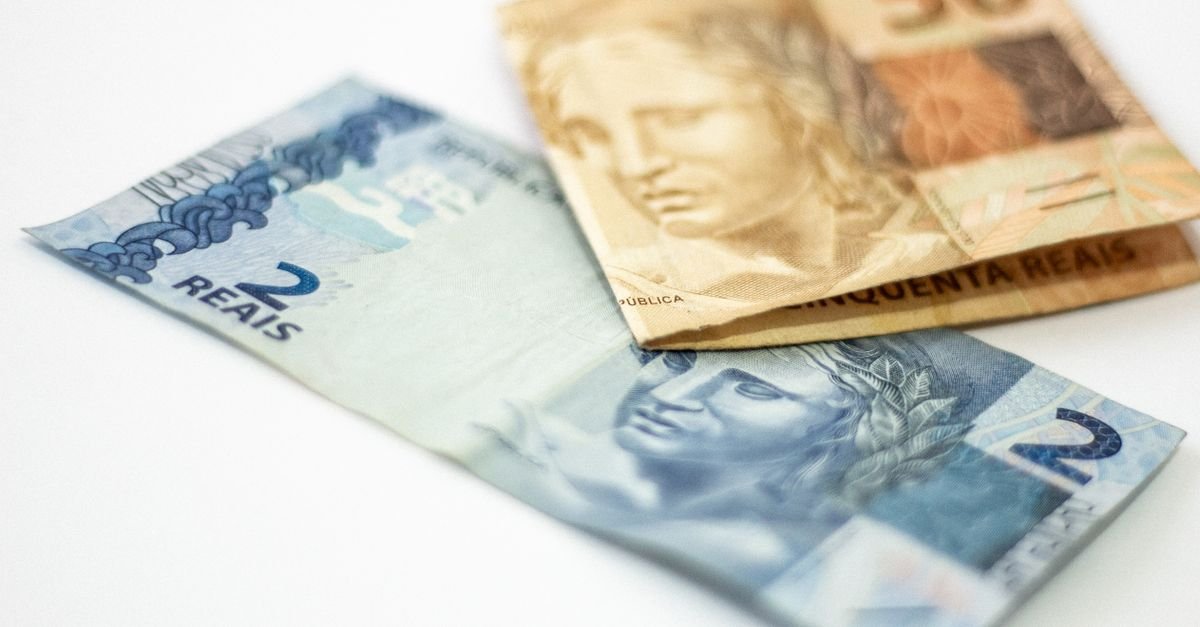 Cédulas de 2 e 50 reais sobre fundo branco em close