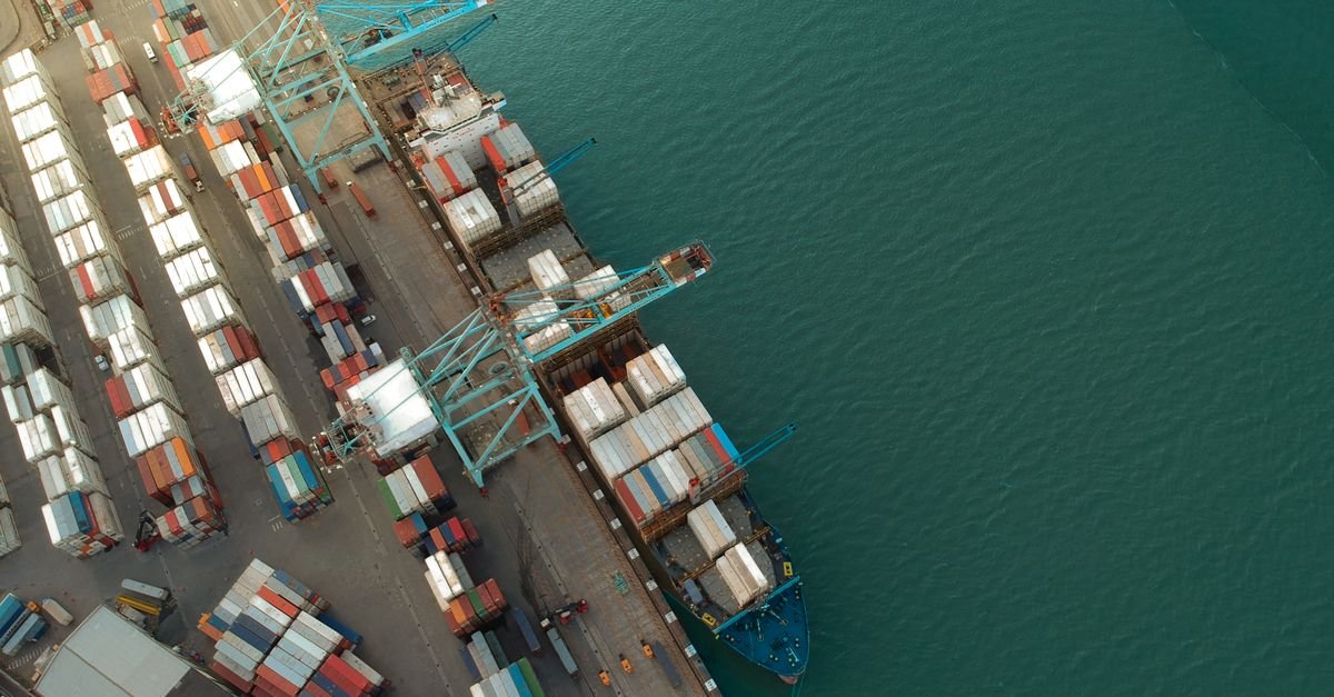Vista aérea de porto de contêineres com navio de carga atracado
