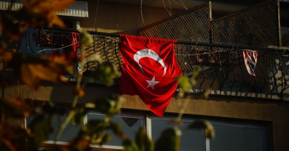 Bandeira da Turquia estendida na sacada de um prédio