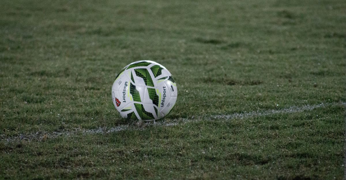 Bola de futebol sobre o gramado à noite antes de partida