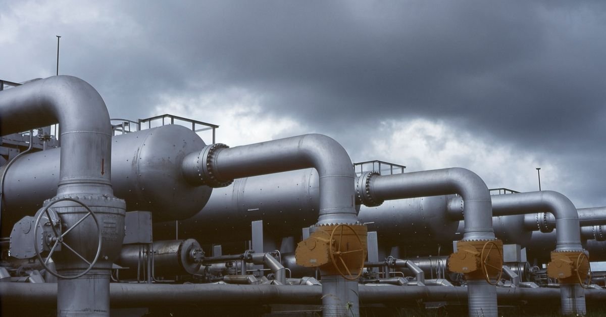 Tubulações e vasos de pressão de uma planta industrial petroquímica sob céu nublado