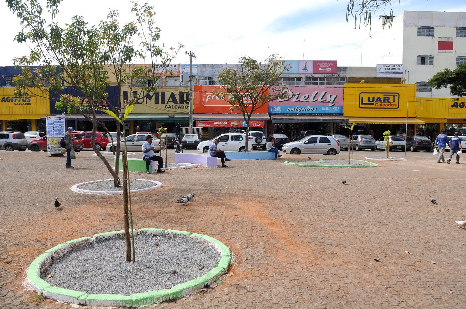 Comércio de rua no centro de Ceilândia, no Distrito Federal, com lojas, toldos e pedestres