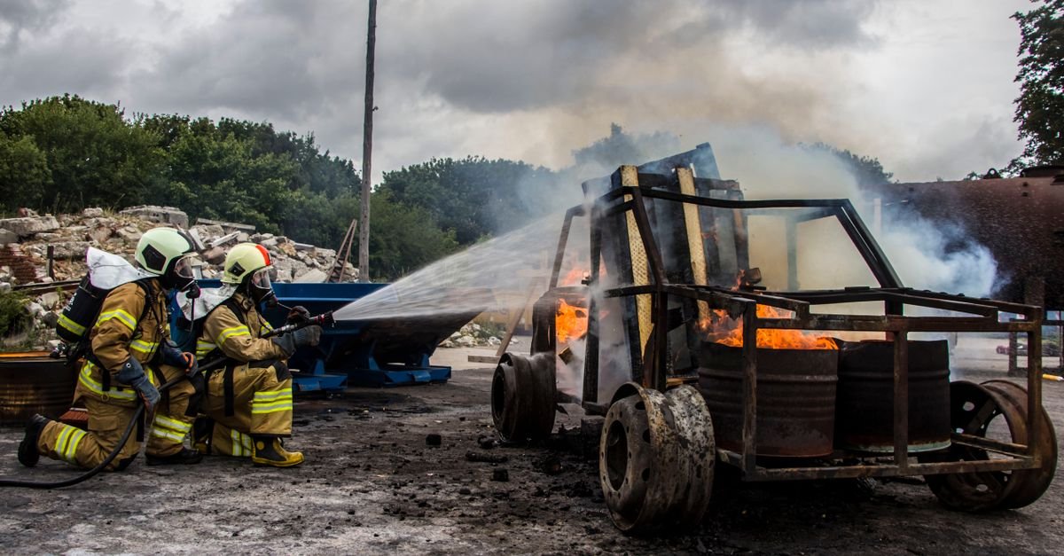 Bombeiros combatem com jato de agua o incendio em um veiculo de carga