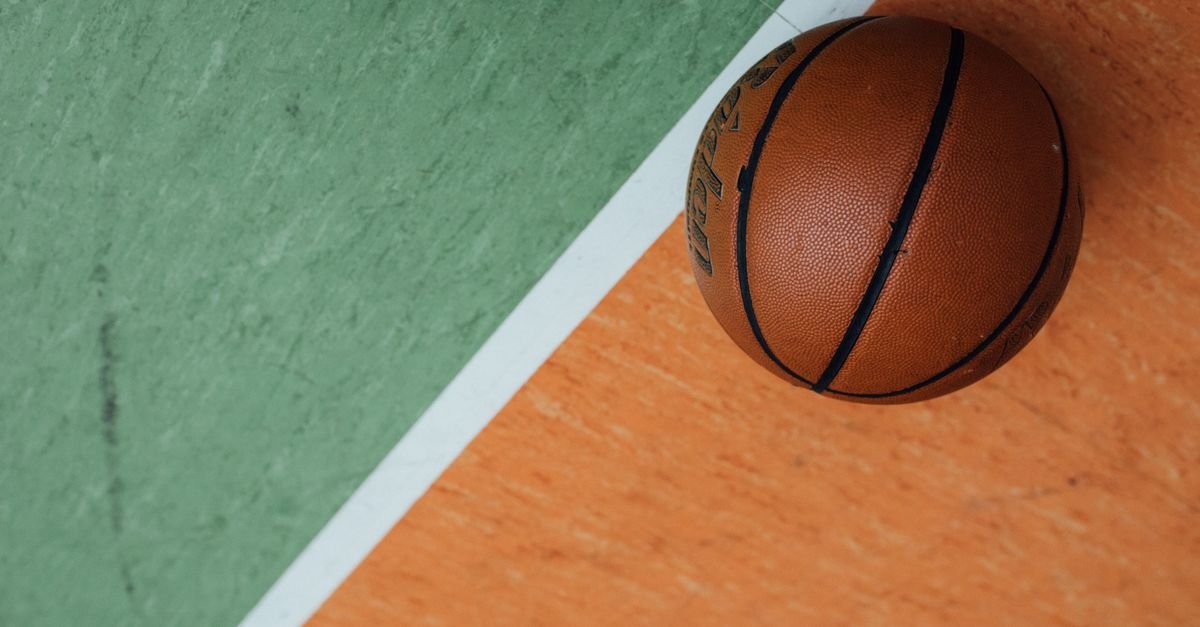 Bola de basquete sobre quadra verde e laranja