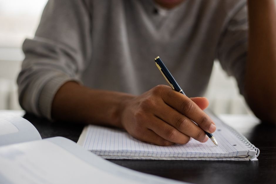 Estudante faz anotações em caderno durante estudo