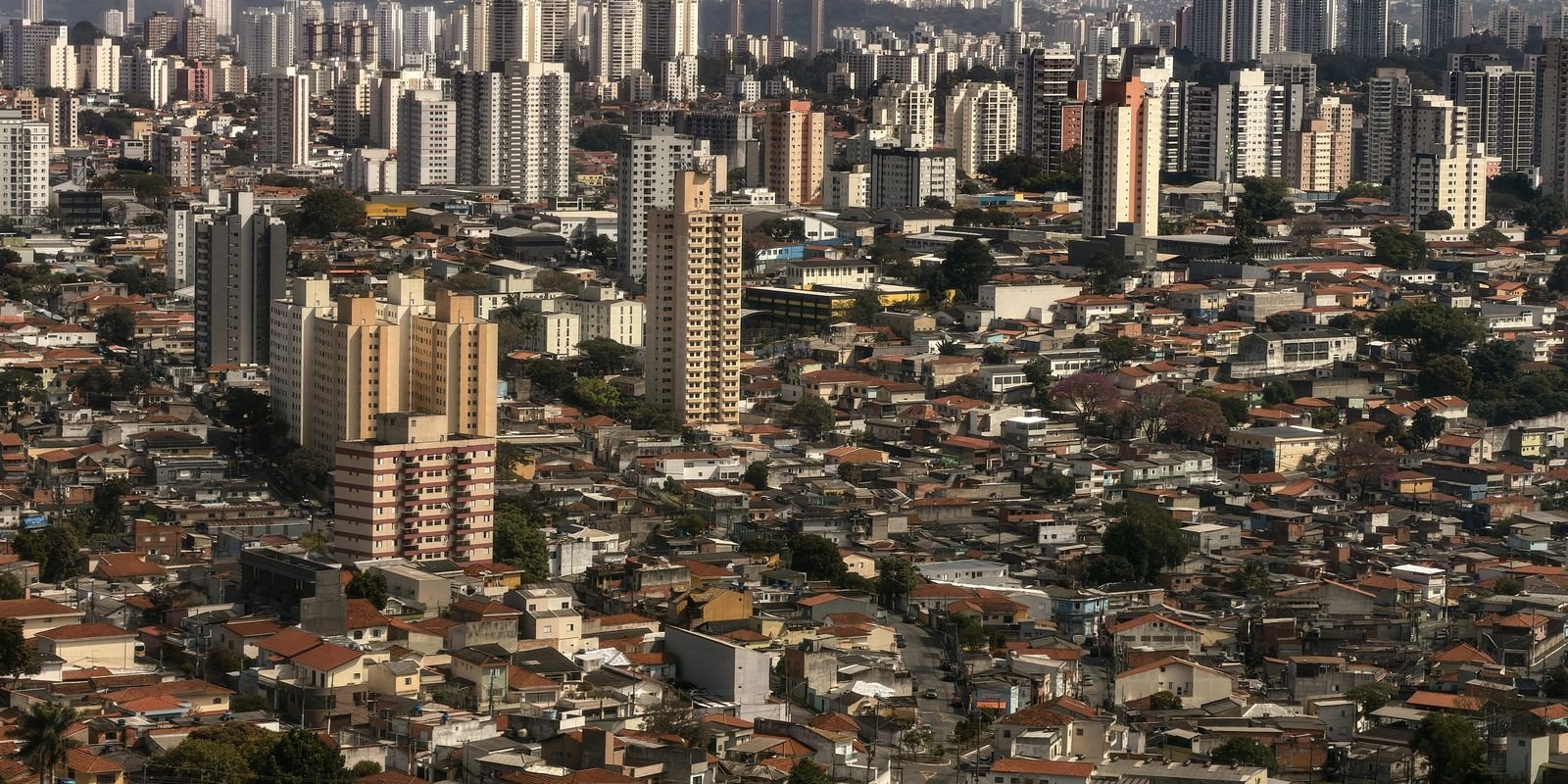Vista aérea de área urbana brasileira com prédios e casas de telhado de cerâmica