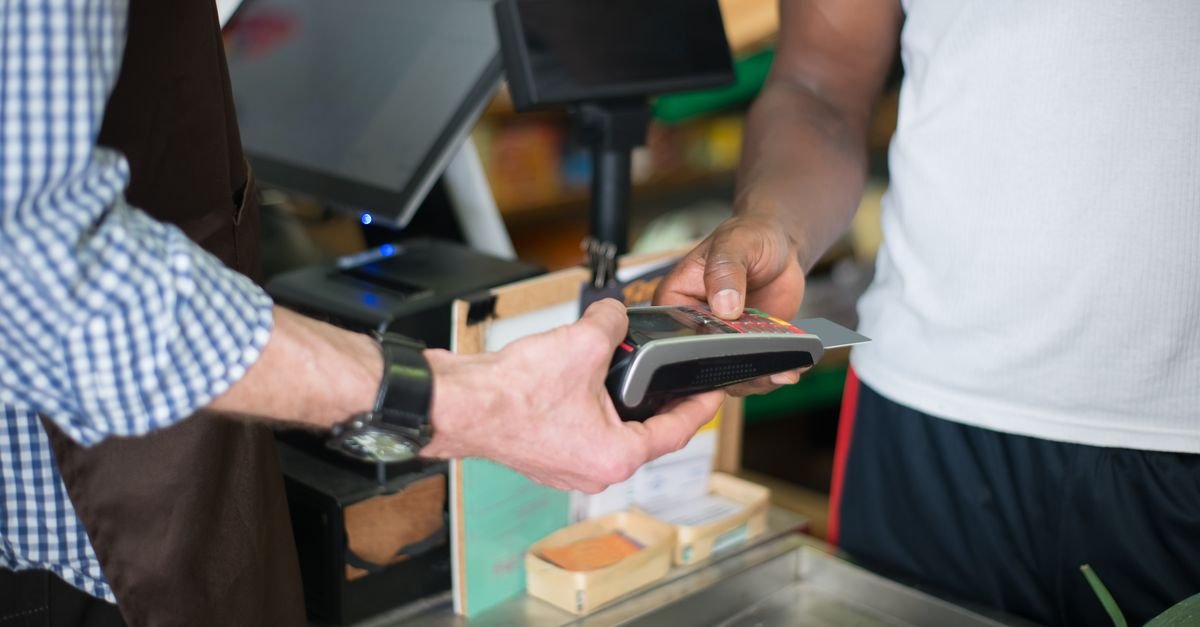 Cliente faz pagamento com cartão em balcão de comércio