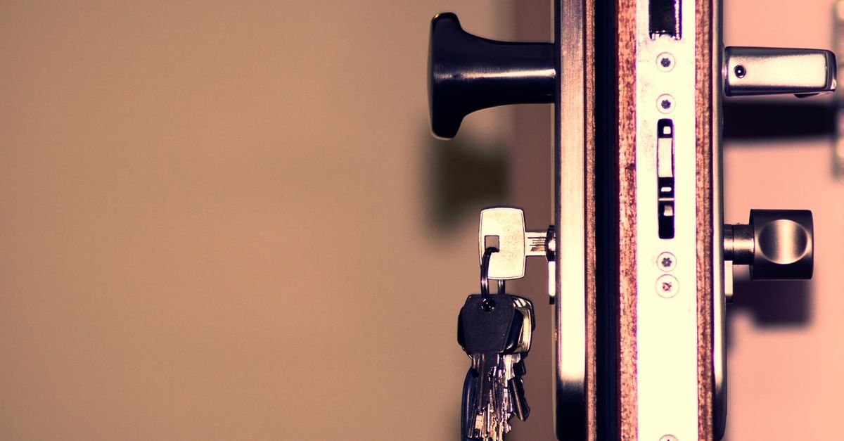 Molho de chaves pendurado na fechadura de uma porta