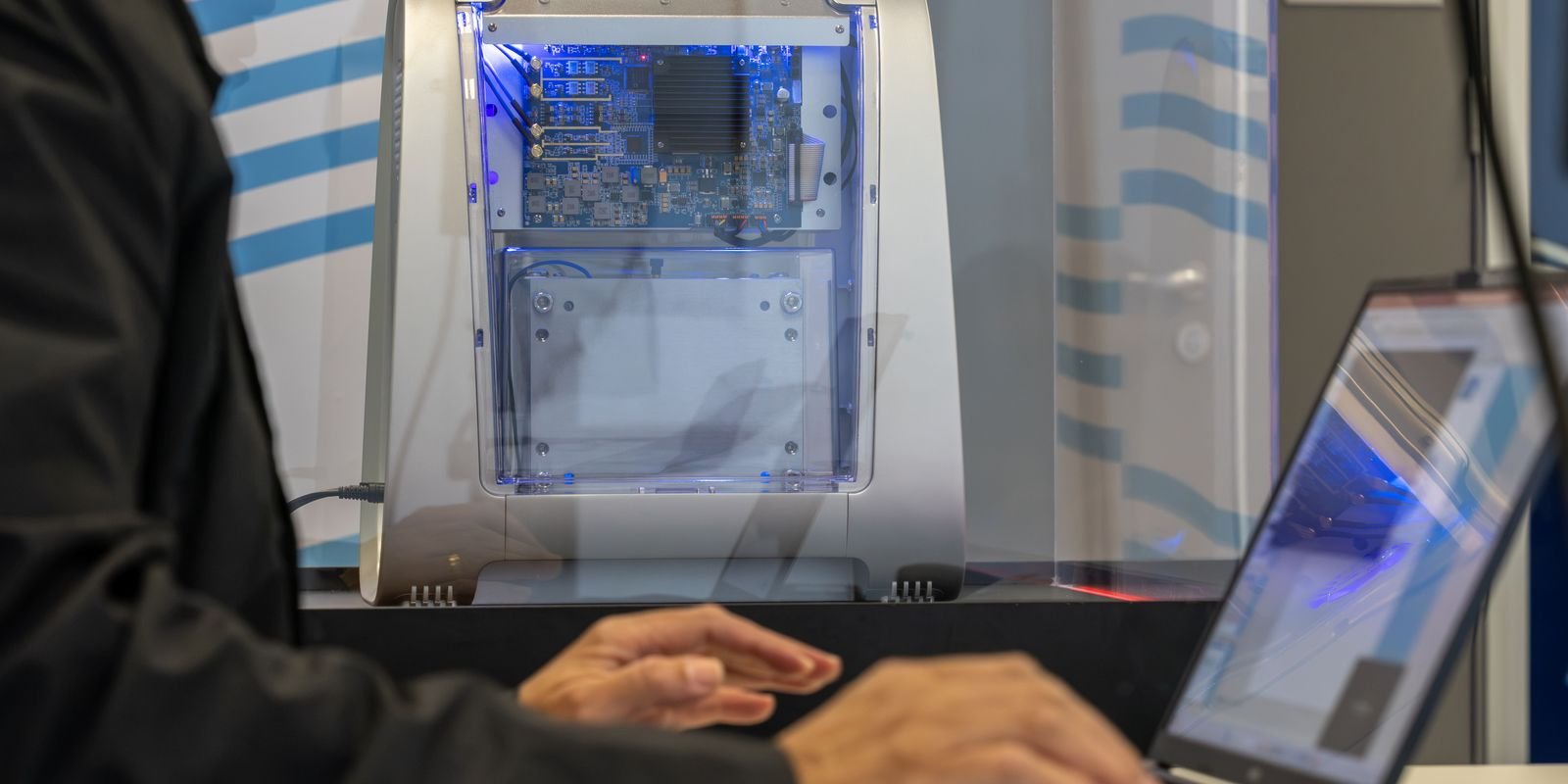 Computador quântico educacional com placa eletrônica visível e luz azul