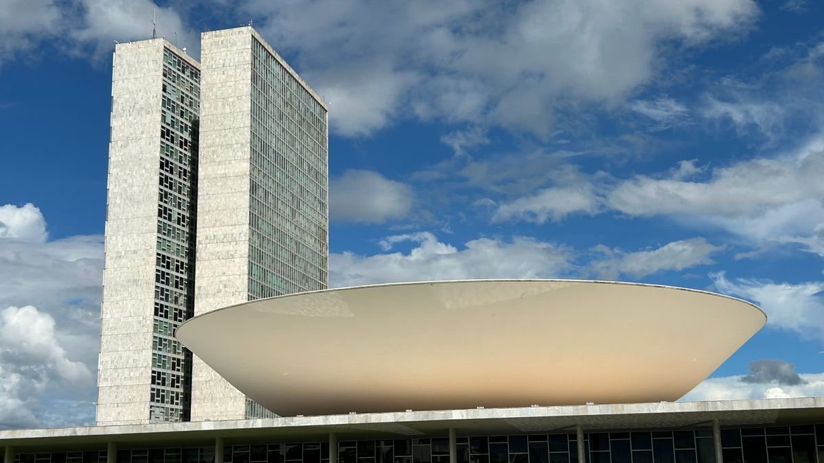Prédio do Congresso Nacional em Brasília sob céu azul com nuvens