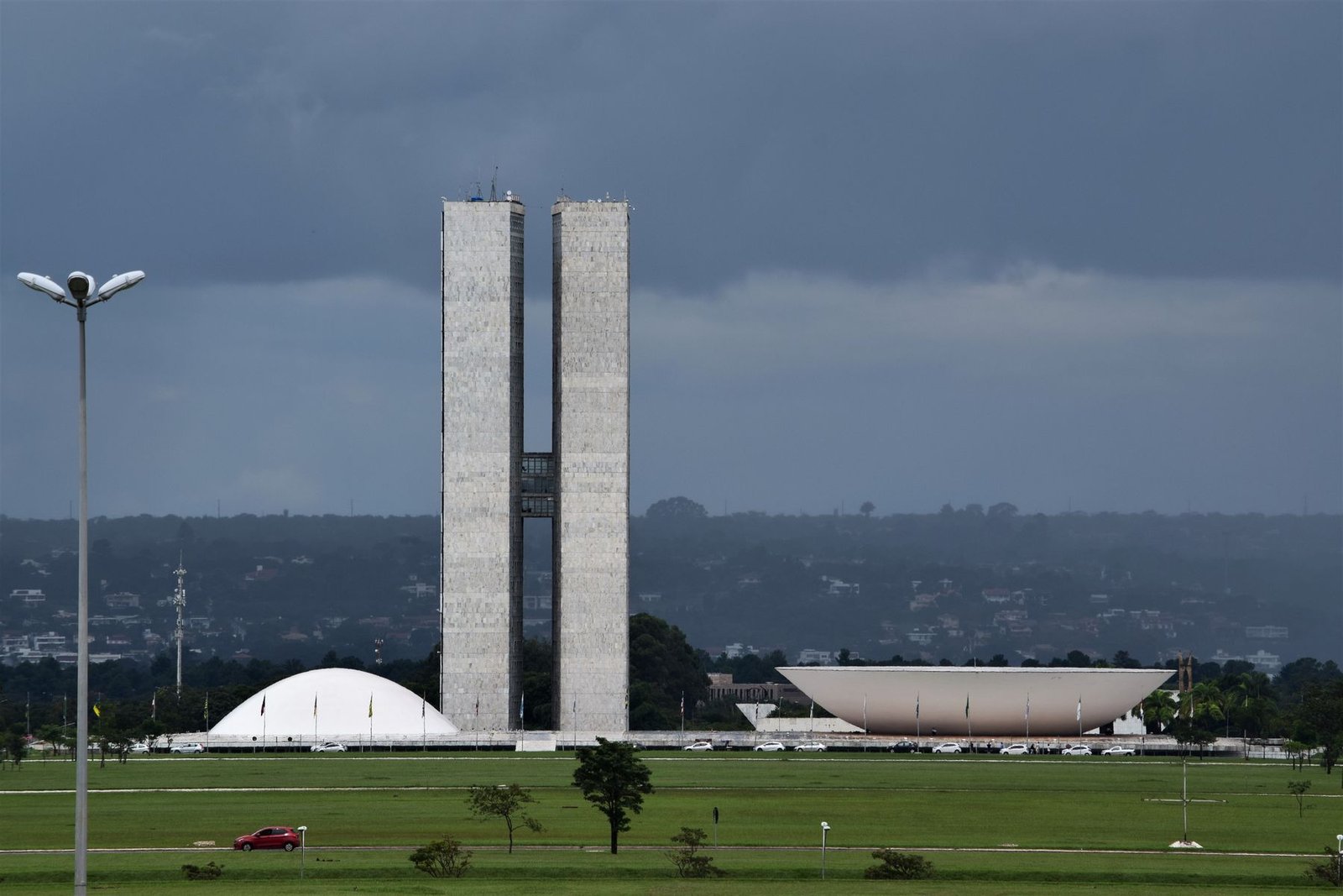 Torres do Congresso Nacional e cúpulas da Câmara e do Senado sob céu carregado, em Brasília