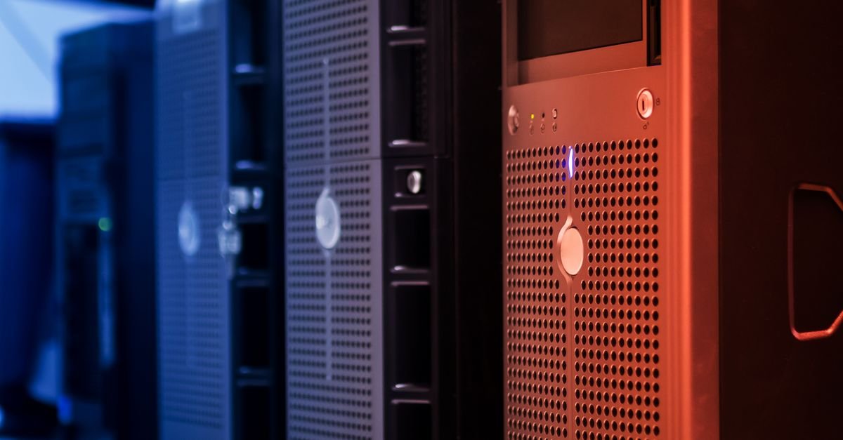 Servidores enfileirados em um data center, com iluminação azul e vermelha