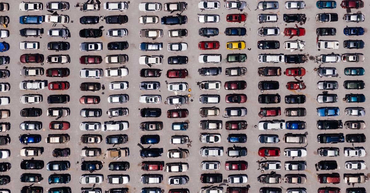 Vista aérea de pátio com centenas de veículos estacionados em fileiras