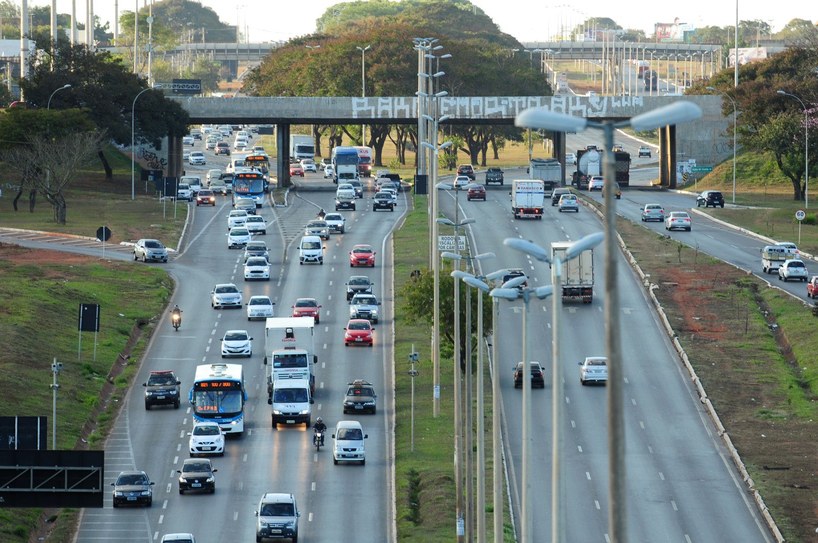 Vista aérea de rodovia do Distrito Federal com seis faixas de tráfego, ônibus e caminhões, em foto de arquivo do DER-DF