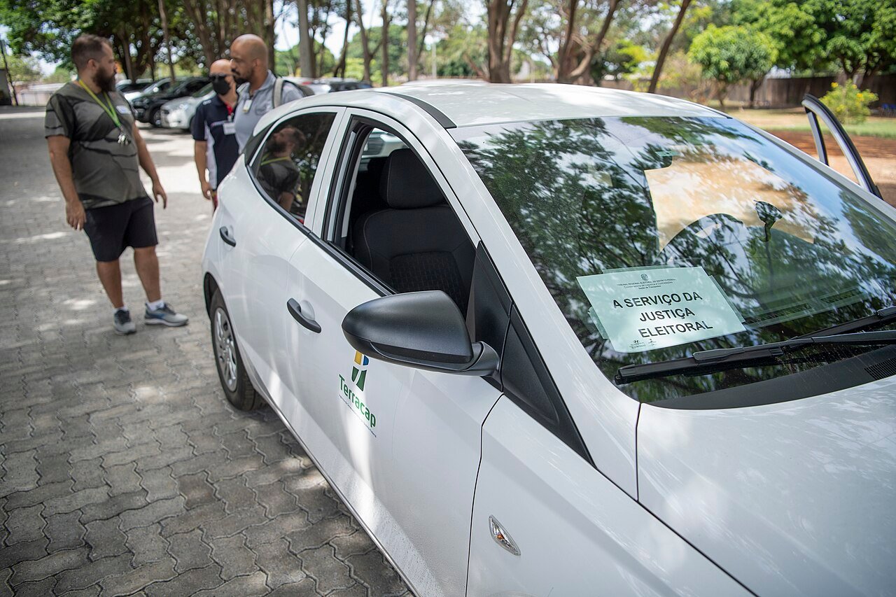 Veículo com cartaz A Serviço da Justiça Eleitoral estacionado em frente a local de votação no Gama, no Distrito Federal