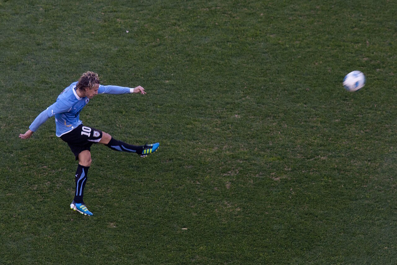 Diego Forlán com a camisa 10 da seleção do Uruguai chuta a bola em campo, em imagem de 2011