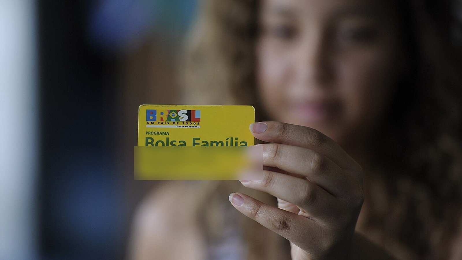 Cartão do Bolsa Família e documentos sobre mesa em atendimento do programa social