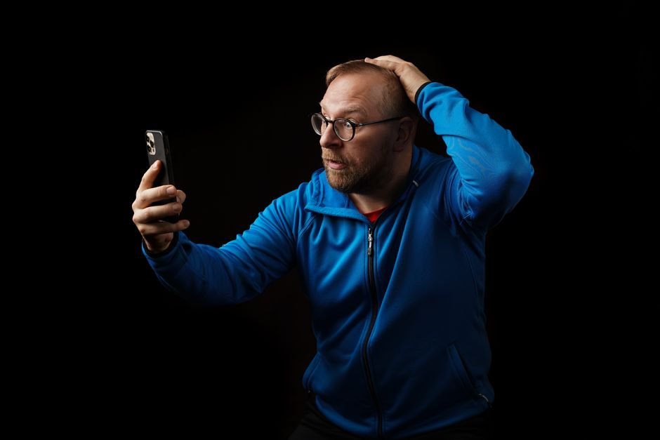 Homem assustado olha alerta de emergencia no celular