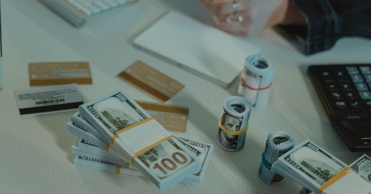 Close-up of dollar bills and credit cards on a desk, symbolizing financial transactions.