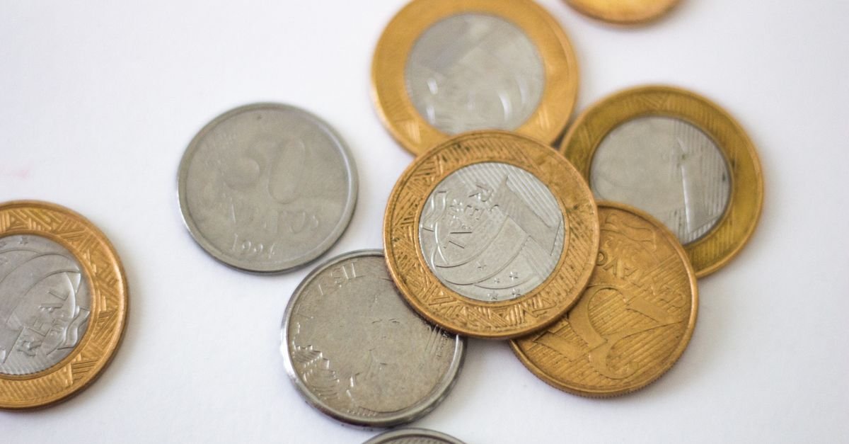 Detailed close-up of Brazilian coins displaying various denominations on a clean white surface.