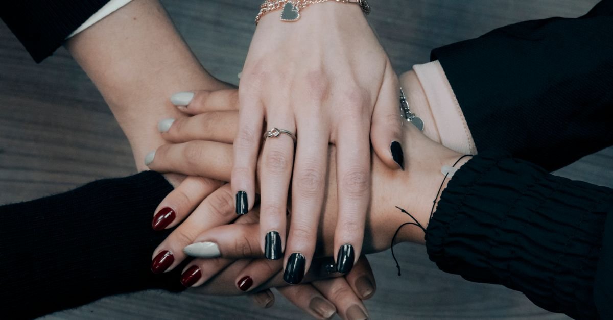 Close-up of diverse hands stacking together symbolizing teamwork, unity, and collaboration.