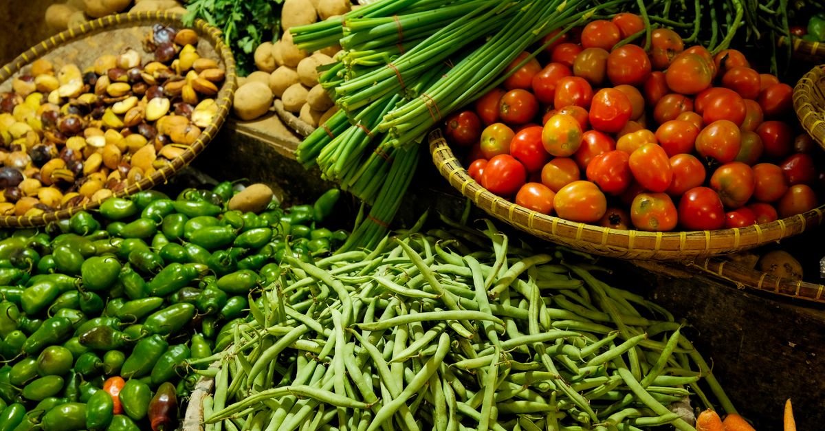 Colorful assortment of fresh vegetables in a local market setting.