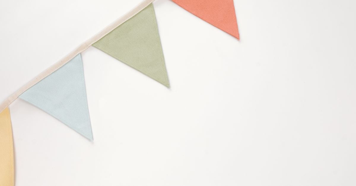 Minimalist image of colorful triangular bunting garland on white background.