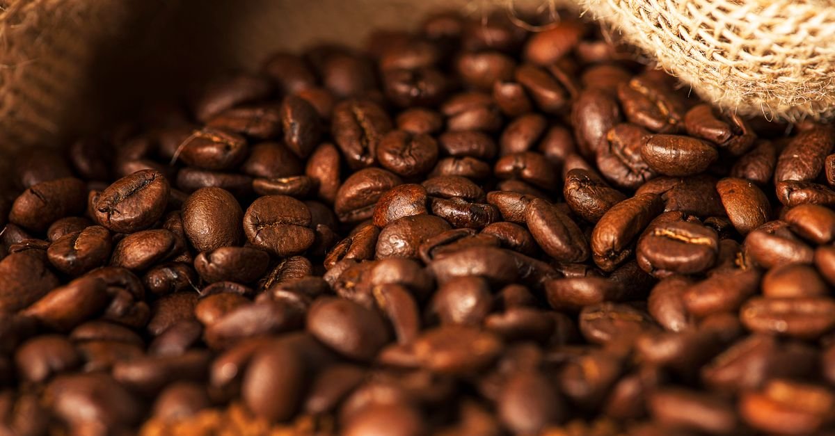 Richly textured image showcasing aromatic roasted coffee beans spilling from a burlap sack.
