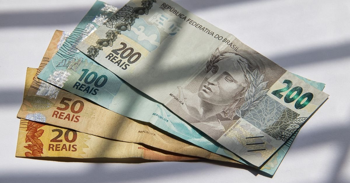 Various Brazilian real banknotes in sunlight, showcasing currency variety.