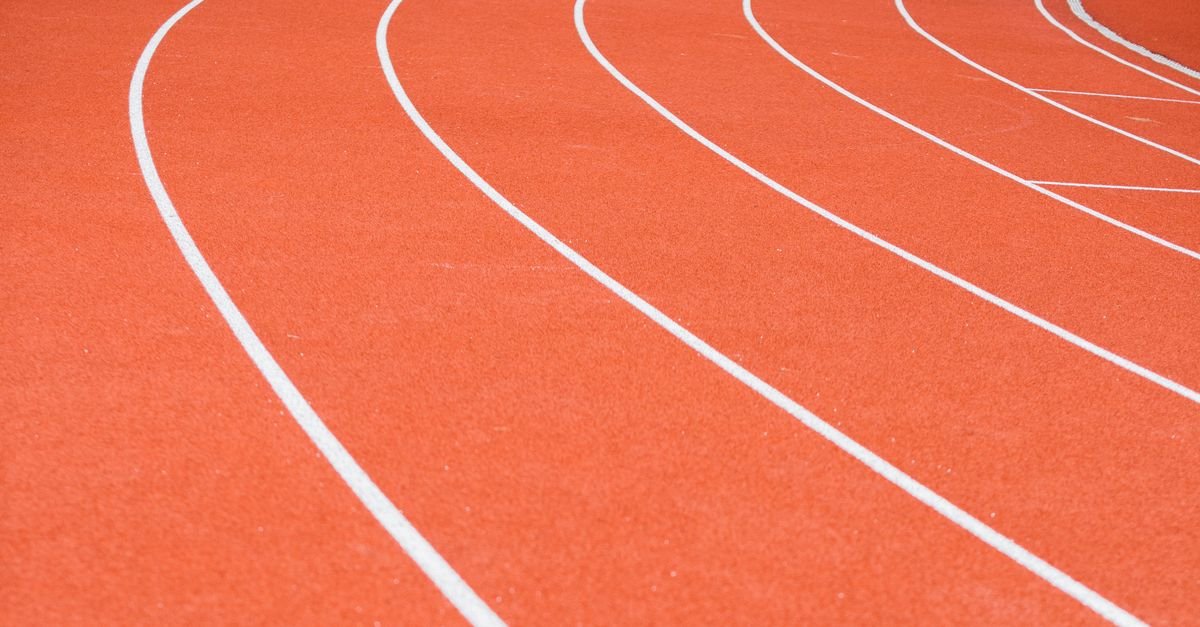 Red running track with distinct white lane markings and rubberized surface.