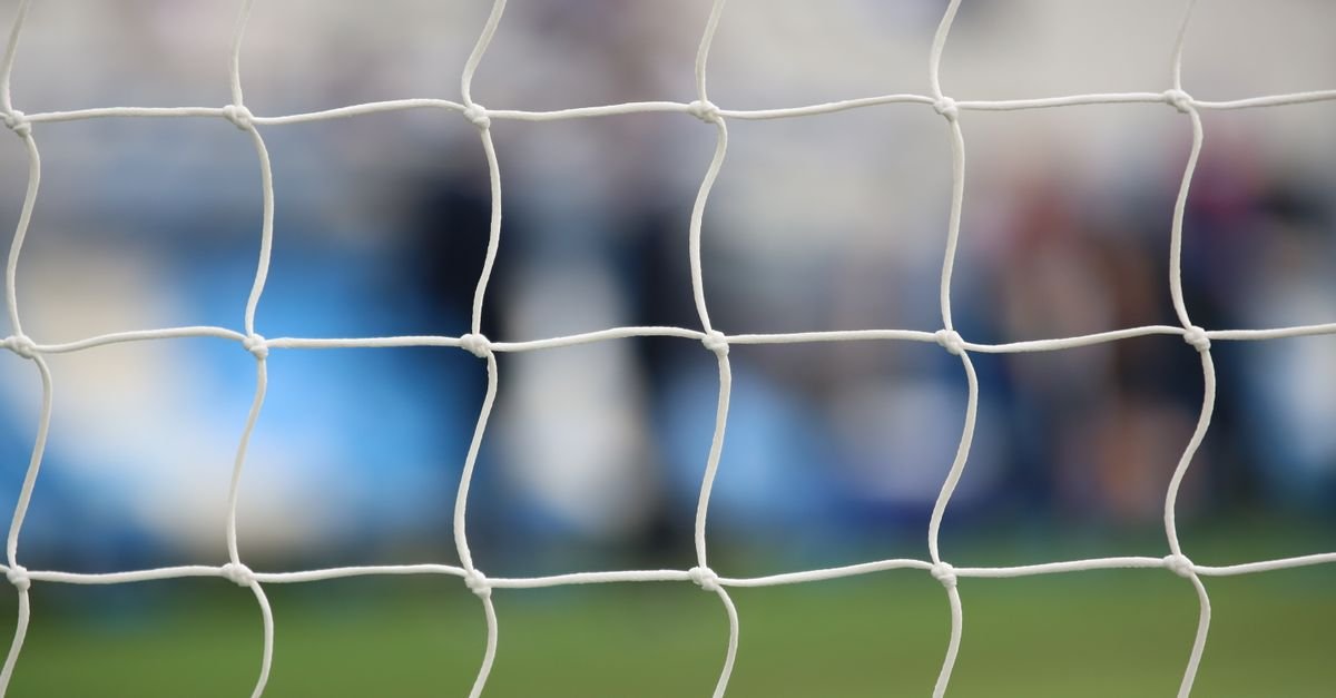 Close-up view of a soccer net with a blurred background of a sports field in Saint-Denis, France.