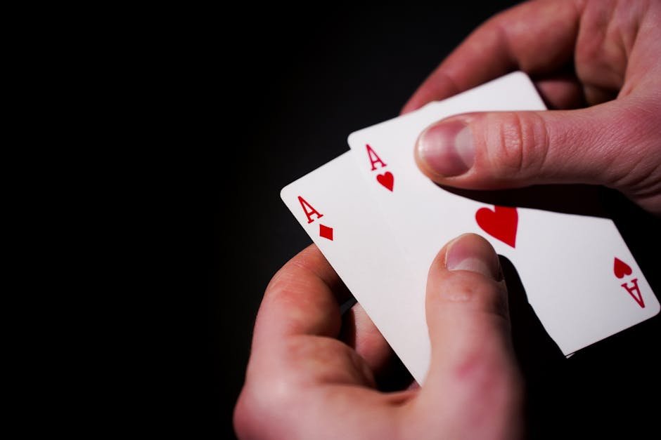 Mãos segurando cartas de baralho contra fundo escuro
