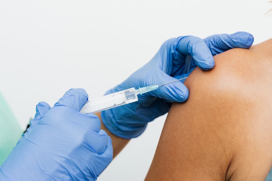 Profissional aplicando vacina no braço de paciente em clínica