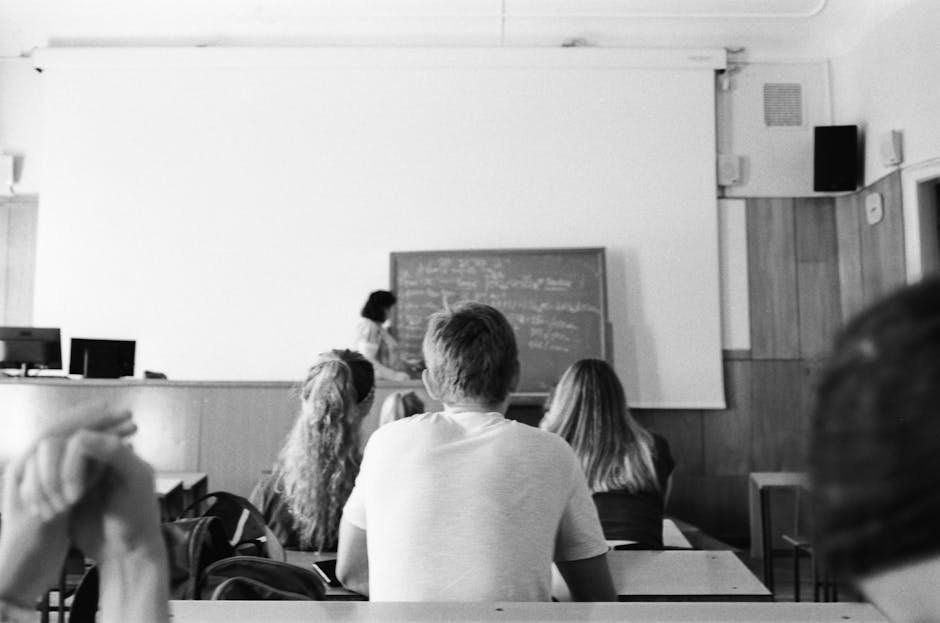 Sala de aula com lousa, professora e alunos em vista de cima