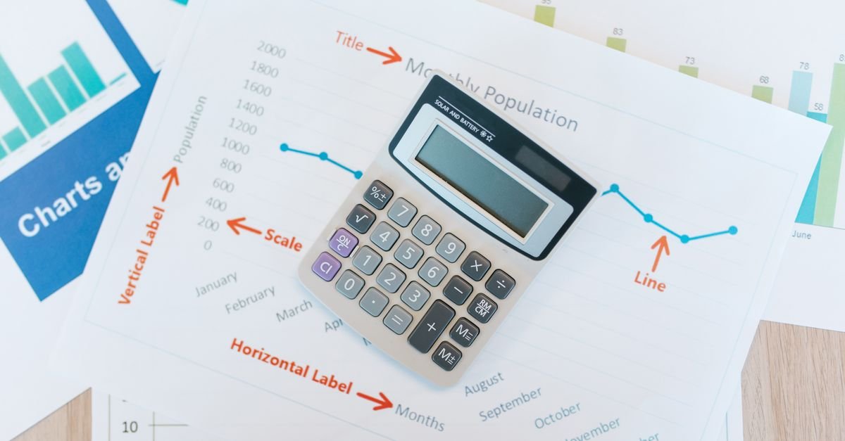 Calculator placed on financial graphs and reports showcasing data analysis and business documentation.