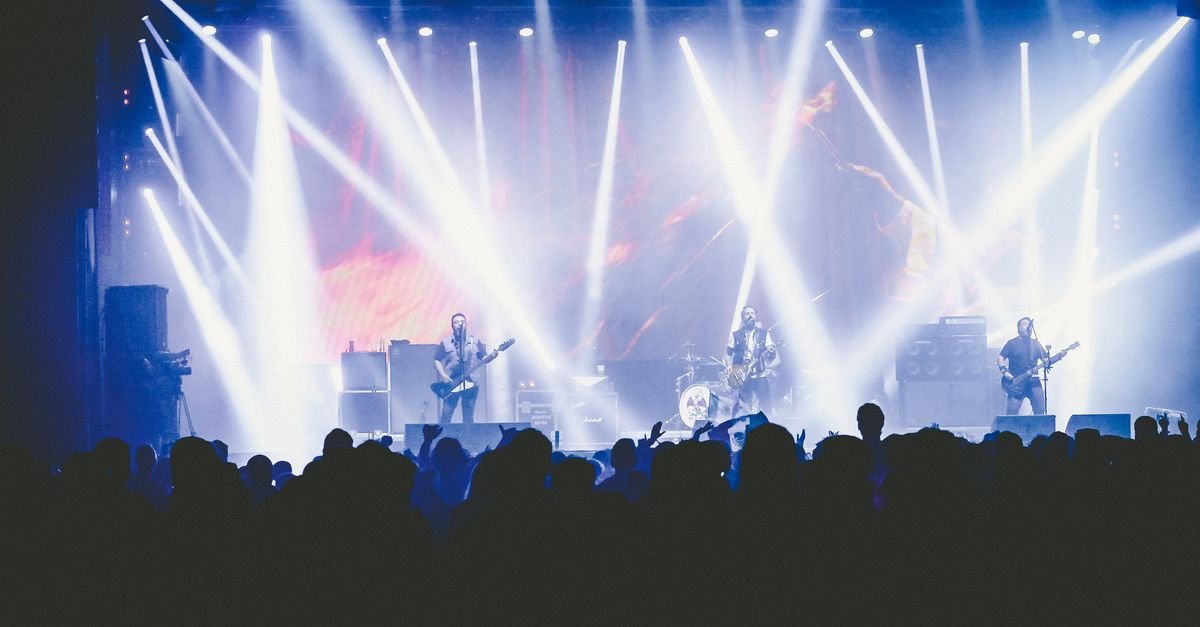 Energetic live concert with a band performing on stage under bright lights.