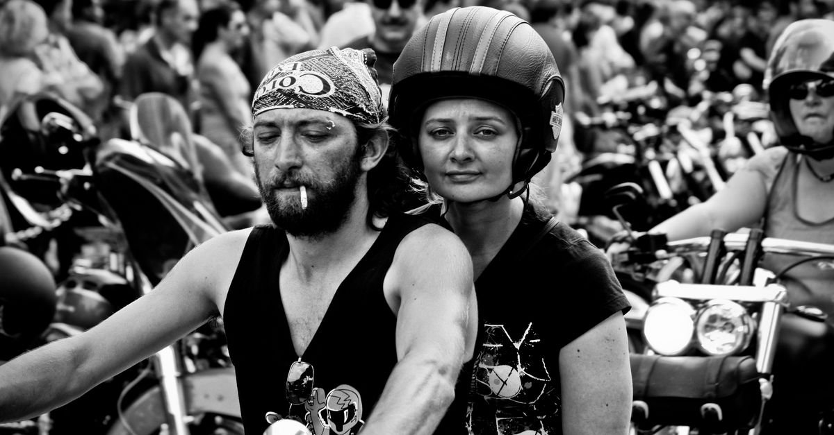 A group of motorcyclists in a crowd, captured in striking black and white.