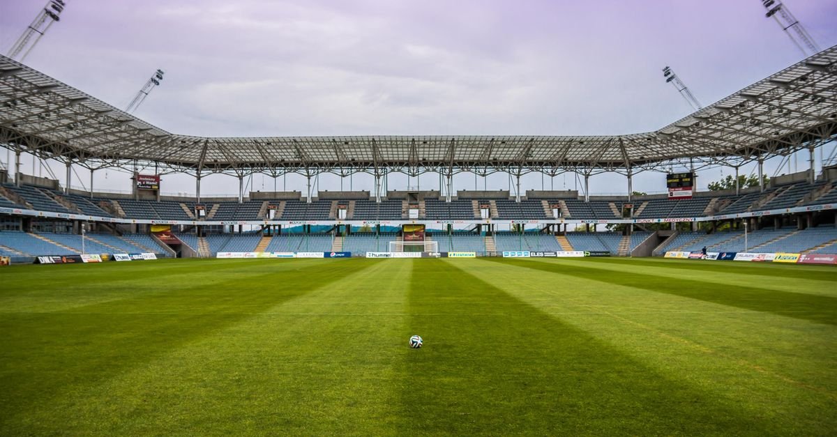 Explore a soccer stadium with clear skies and pristine grass, perfect for any sports event.