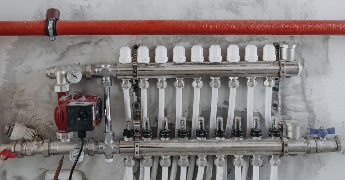 A close-up view of an industrial manifold with pressure gauges and connected steel pipes.