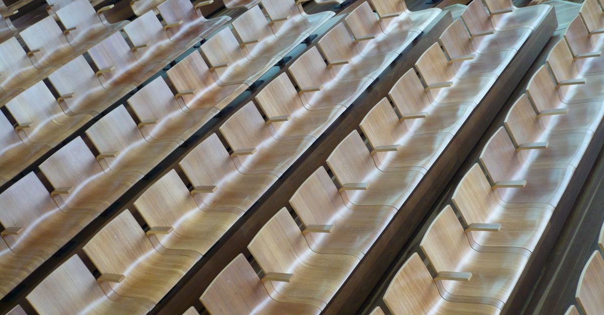 Rows of wooden seats in a modern, empty auditorium showing an elegant interior design.