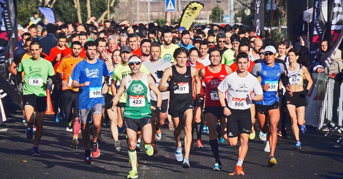 A large group of marathon runners competes outdoors in broad daylight, showcasing endurance and fitness.