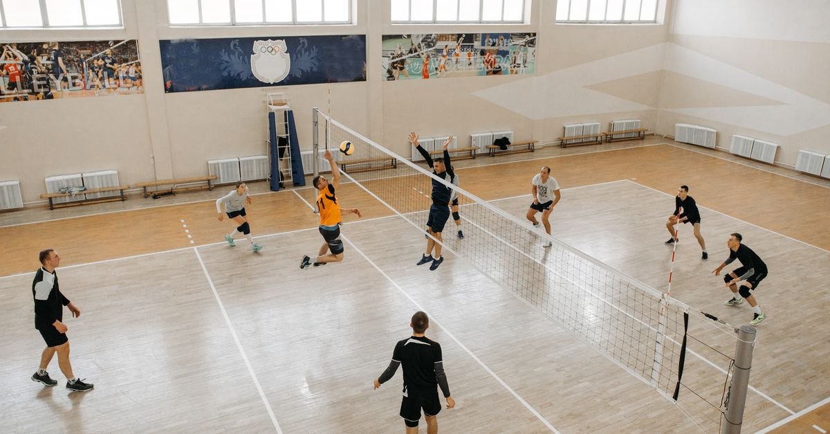 High-energy indoor volleyball game with teams competing intensely on the court.
