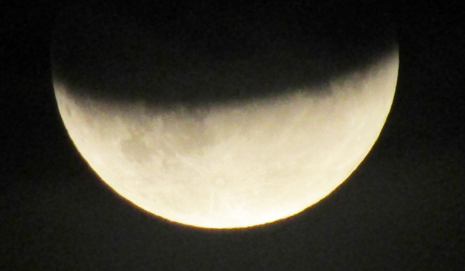 Lua vista de perto com a parte superior escurecida pela sombra da Terra durante eclipse lunar parcial
