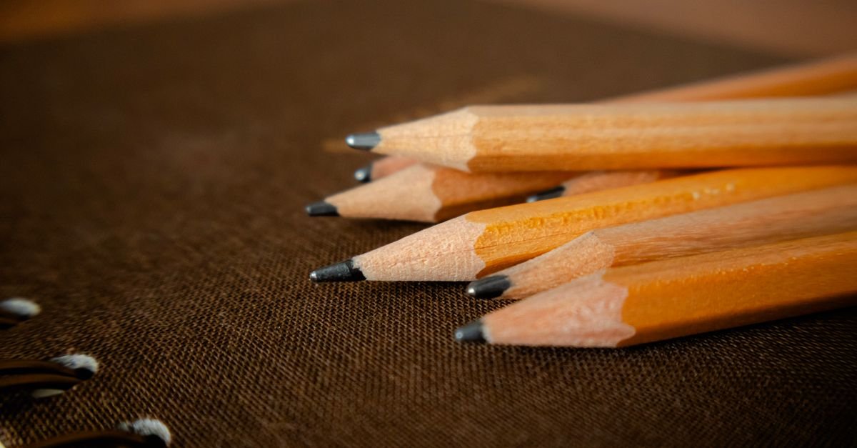 Lápis apontados sobre caderno escolar em close