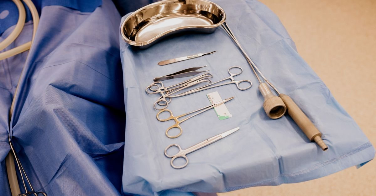 Instrumentos cirúrgicos esterilizados dispostos sobre campo azul em sala de cirurgia