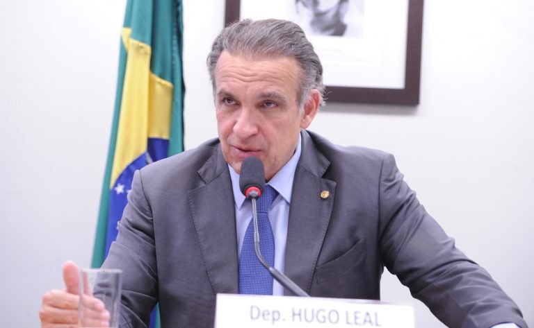 Deputado Hugo Leal fala ao microfone durante reunião de comissão na Câmara